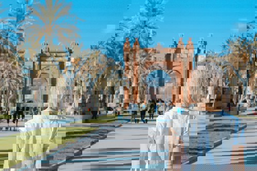 Arc de triomph in Barcelona with a woman looking at it from a distance